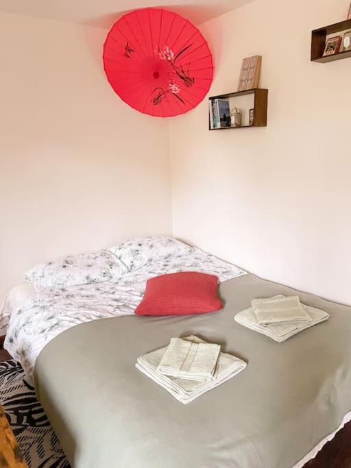 a bedroom with a bed with a red clock on the wall at Charming Rustic Beach House Hideaway in Klaipėda