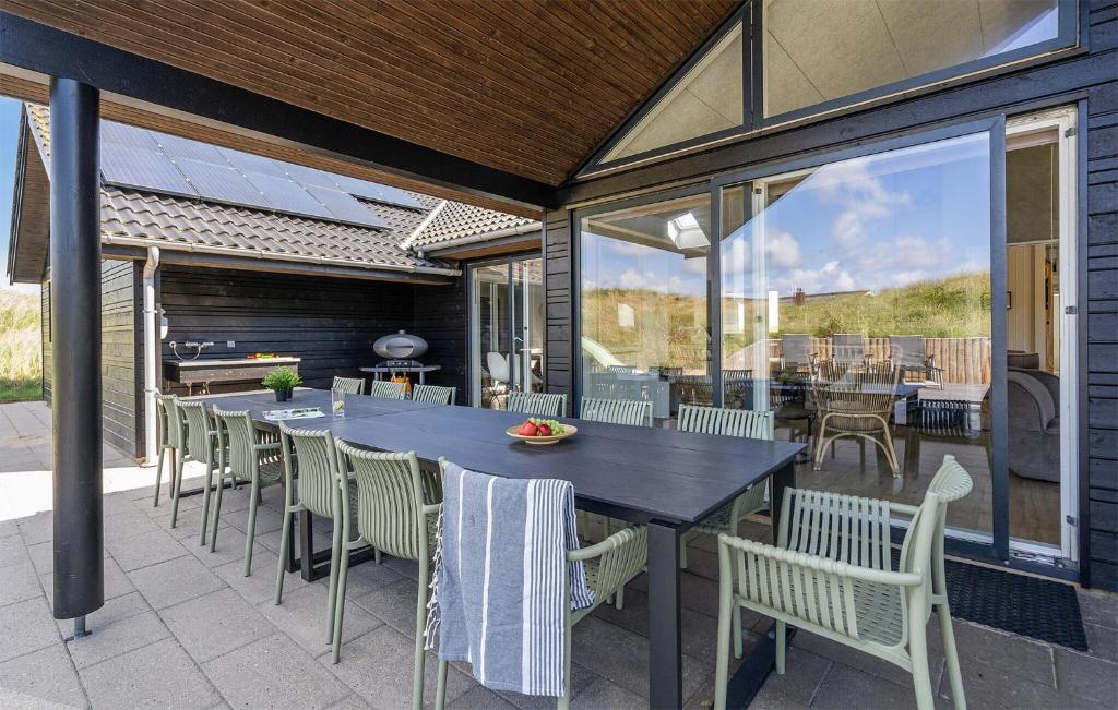 an outdoor patio with a table and chairs at 9 Bedroom Lovely Home In Ringkøbing in Søndervig