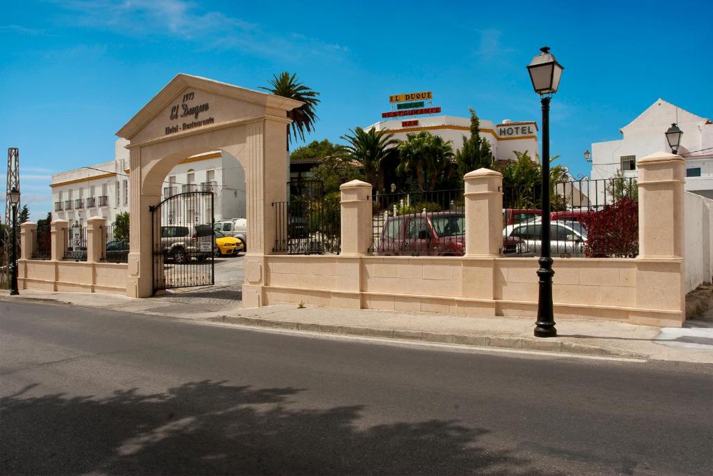 ein Gebäude mit einem Tor an der Straßenseite in der Unterkunft Hotel restaurante El Duque in Medina-Sidonia