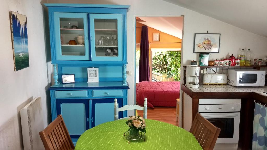 une cuisine avec un meuble bleu et une table dans l'établissement Logement cosy proche gare avec terrasse de verdure, à Saumur