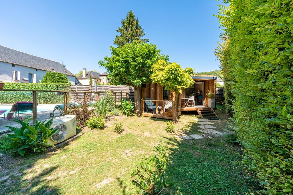 a backyard with a fence and a tree at Chambre d'hôtes de la dame blanche in Borrèze