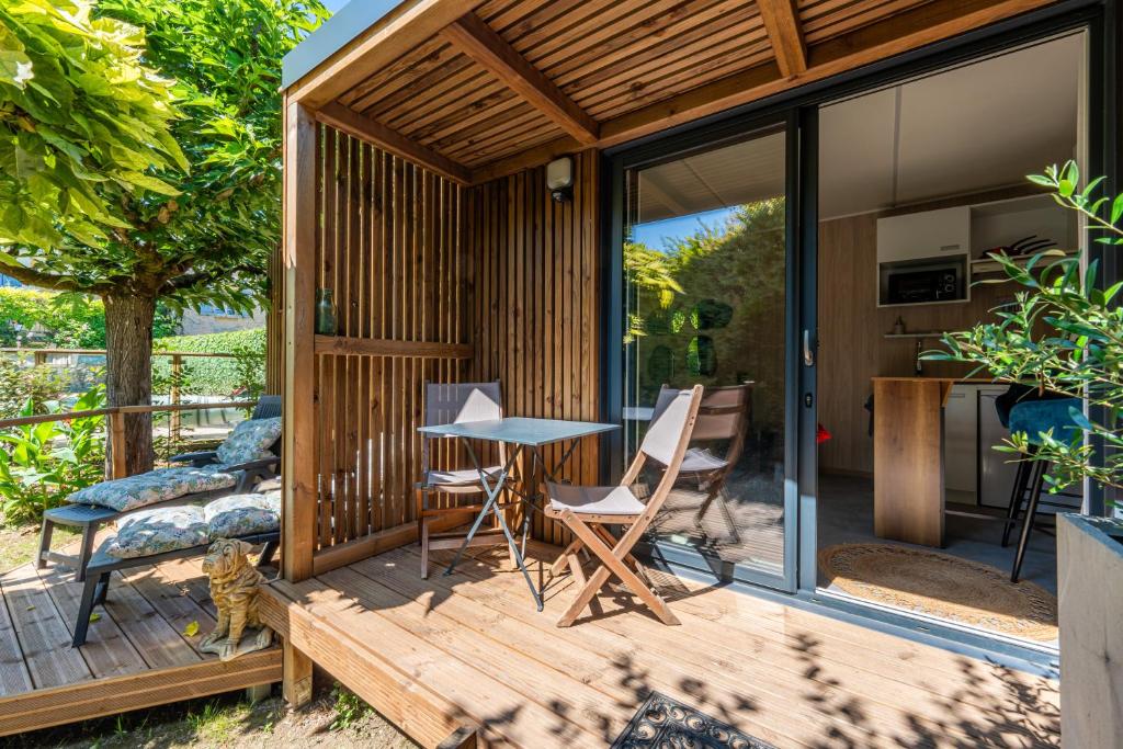 a tiny house with a table and chairs on a deck at Chambre d'hôtes de la dame blanche in Borrèze