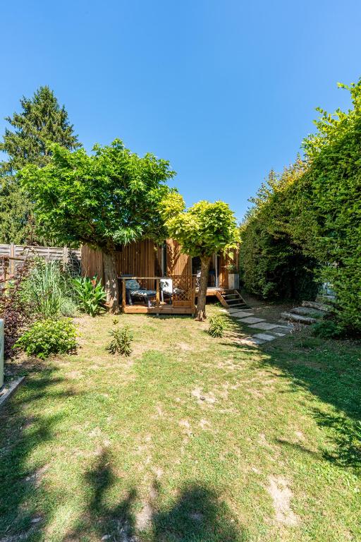a yard with a house with trees and grass at Chambre d'hôtes de la dame blanche in Borrèze
