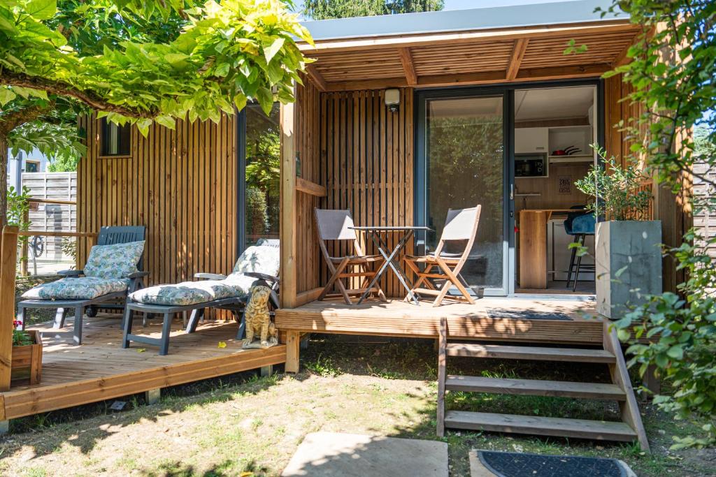 a tiny house with chairs and a table on a deck at Chambre d'hôtes de la dame blanche in Borrèze