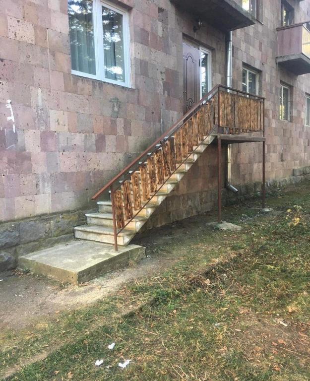 a wooden staircase next to a brick building at Apartment in Dilijan in Dilijan