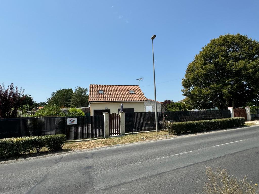 a house on the side of a road with a fence at Chez Malo in Meschers-sur-Gironde