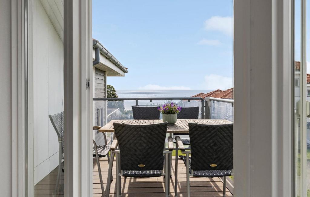 a patio with a table and chairs on a balcony at Gudhjem Søpark Lejl 28 in Gudhjem
