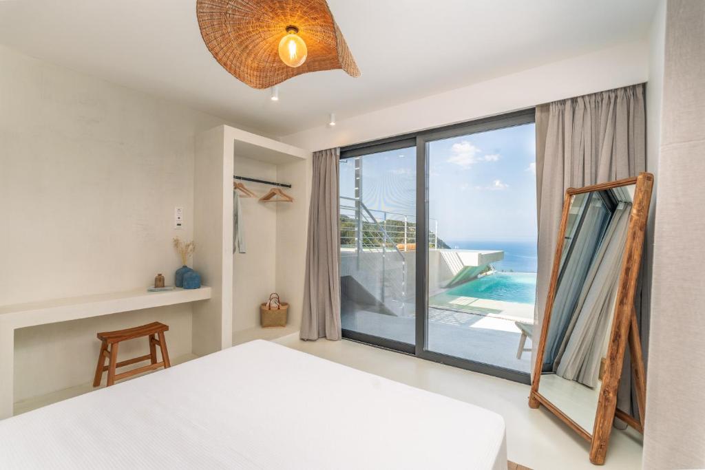 a bedroom with a bed and a view of the ocean at NeRó Villas Lefkada in Tsoukaladhes