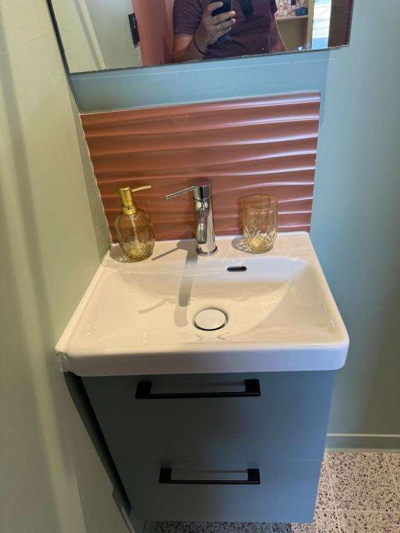 un lavabo blanc dans une salle de bain avec un miroir dans l'établissement Appartement hyper centre, à Bordeaux