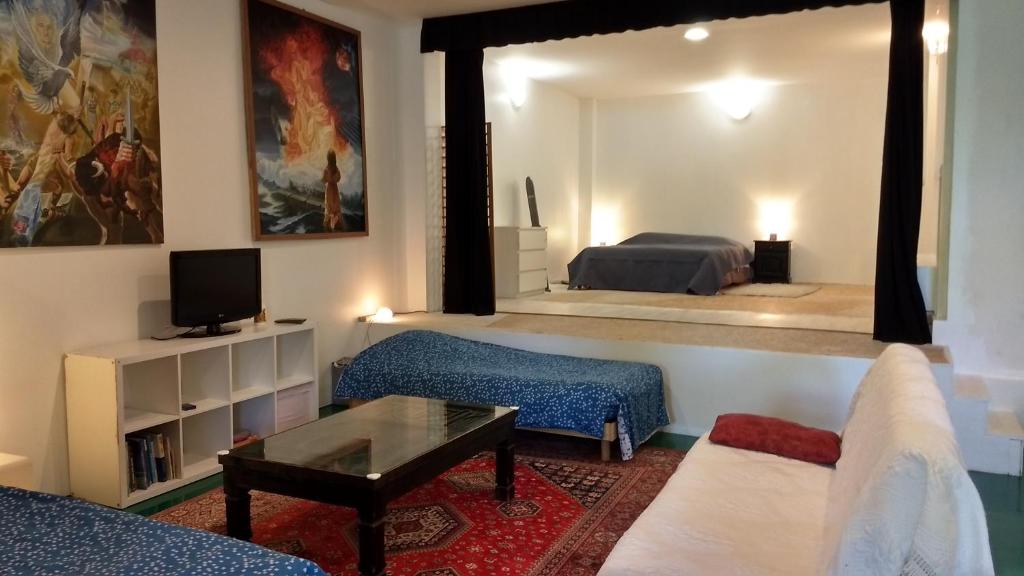 un salon avec un canapé et une chambre avec un lit dans l'établissement Logement spacieux et original proche gare au RDC, à Saumur