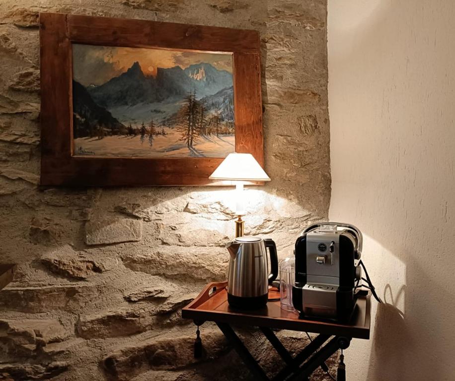 Una mesa con una lámpara y una tostadora encima. en The saxe relax in the mountain, en Courmayeur