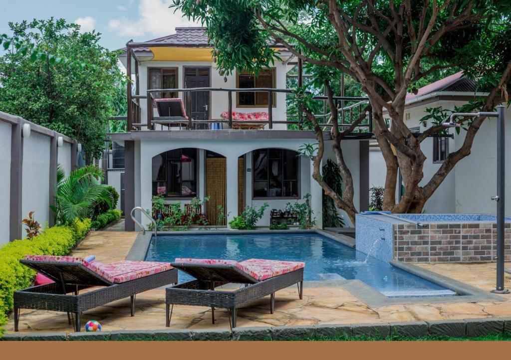 a house with a swimming pool in front of a house at SafariVITA Villa in Moshi