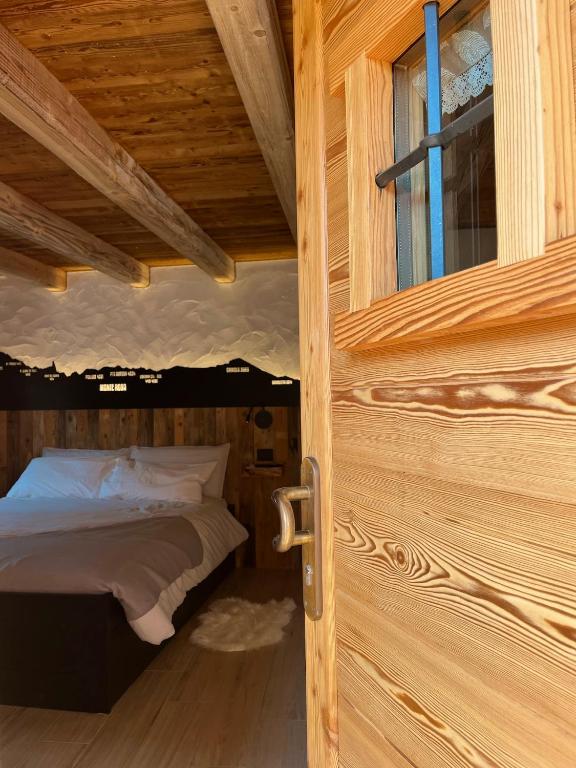 a bed in a wooden room with a window at La famille d'Evian in Villeneuve