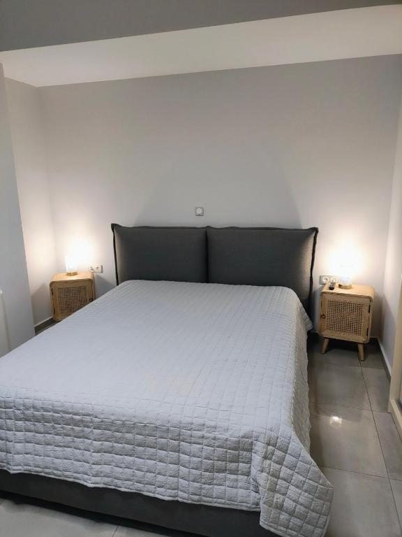 a bedroom with a white bed with two night stands at Kate Apartments in Kokkari