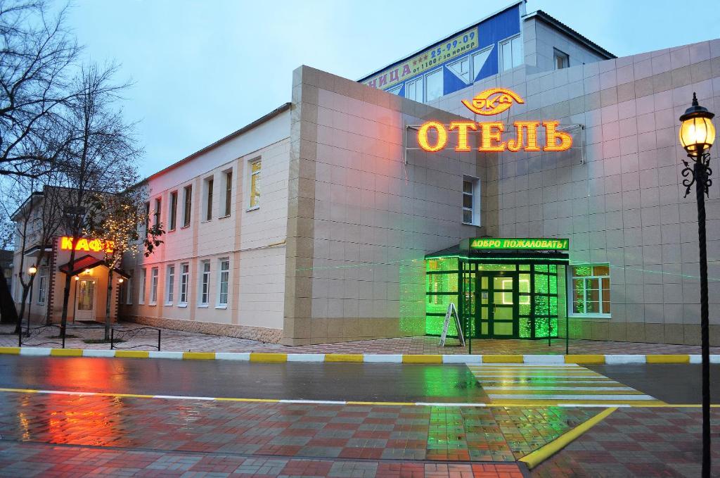 un immeuble de bureaux avec un panneau néon sur celui-ci dans l'établissement Oka Hotel, à Riazan