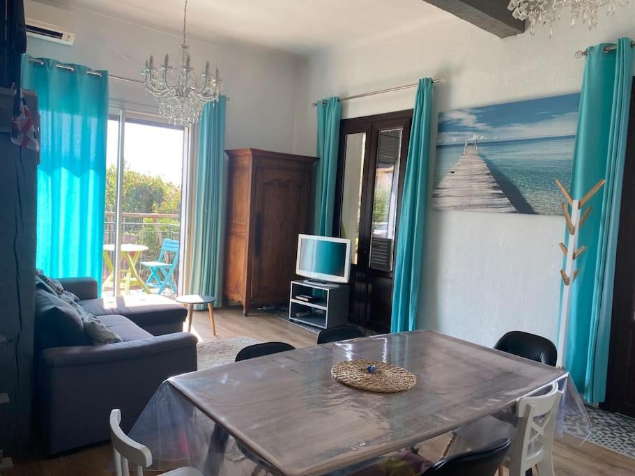 un salon avec une table et une télévision dans l'établissement Rez de villa avec jardin à 6 min des plages, à Cannes