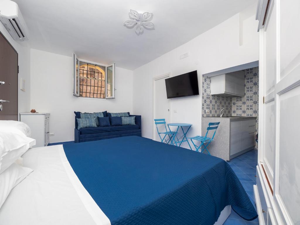 a bedroom with a blue bed and a couch at De Vivo Realty - Camilla House Positano in Positano