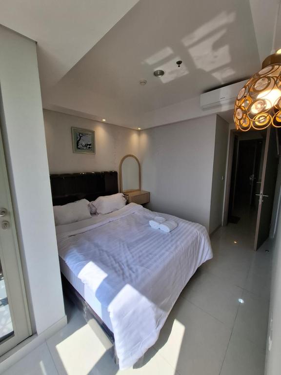 ein Schlafzimmer mit einem großen Bett mit weißer Bettwäsche in der Unterkunft One bedroom gold coast pik in Jakarta