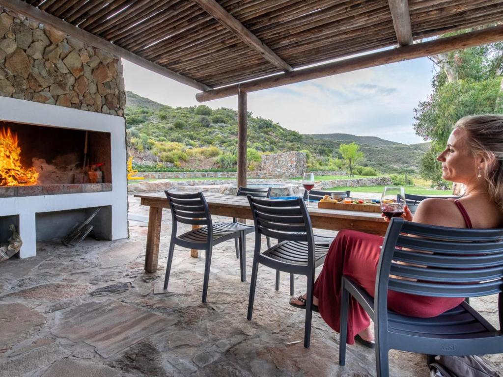 a woman sitting in a chair in front of a fireplace at Ludicks Farm in Montagu