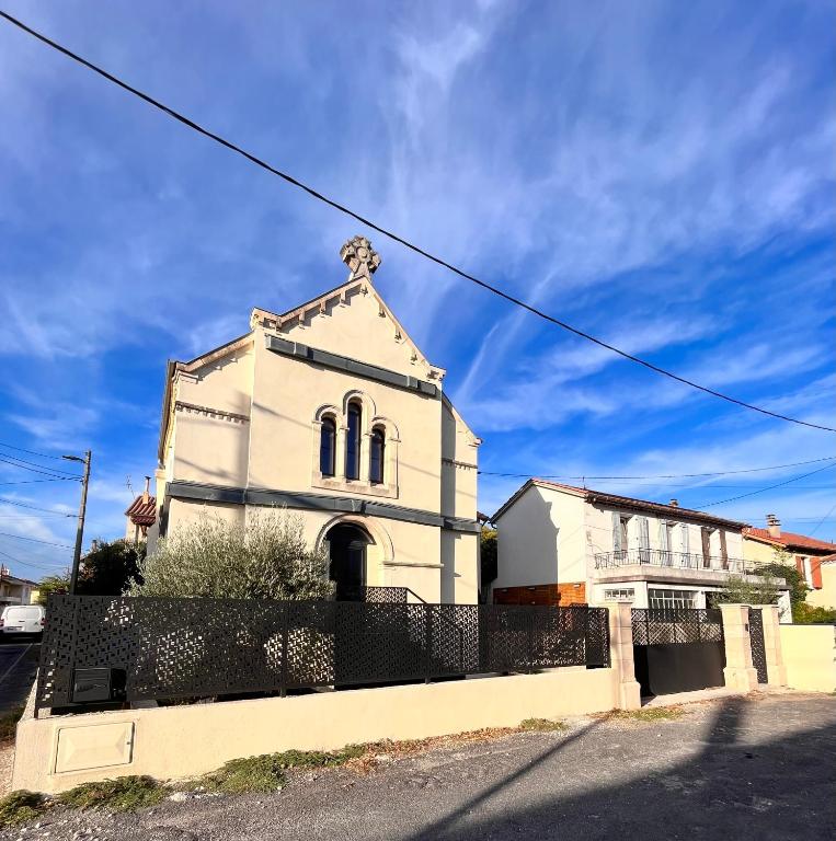 une église blanche avec une clôture devant elle dans l'établissement Ancien temple, à Alès
