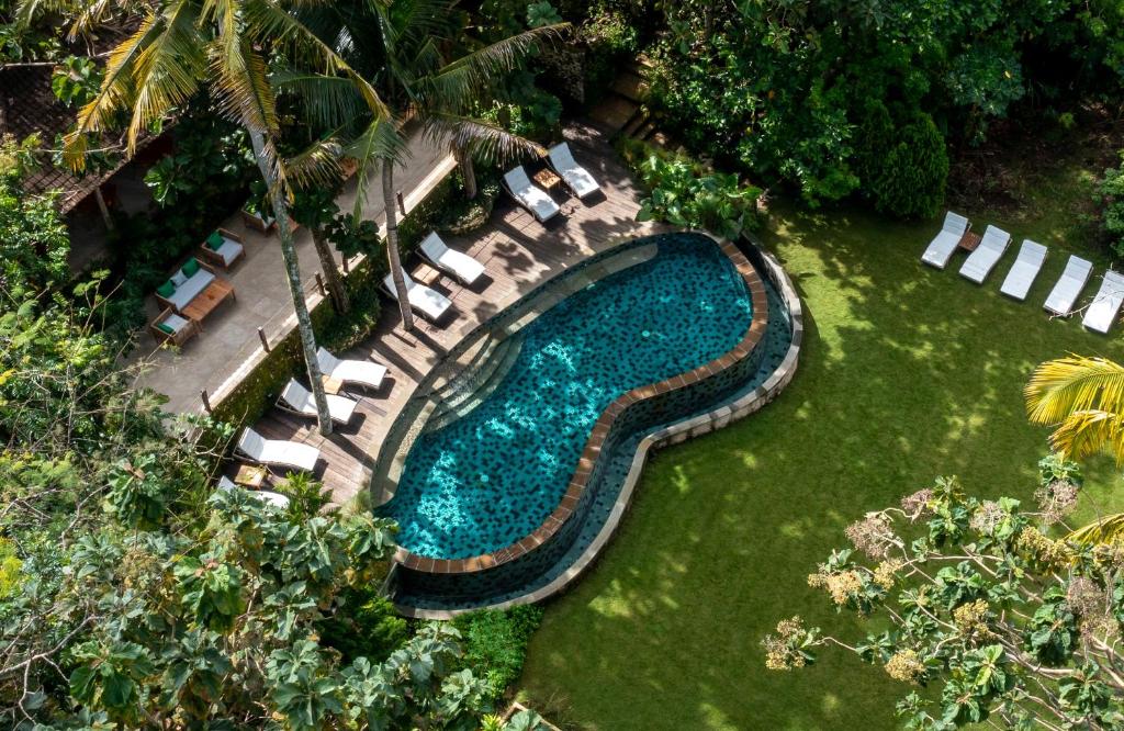 an overhead view of a swimming pool with chaise lounges at The Mesare Eco Resort in Nusa Penida