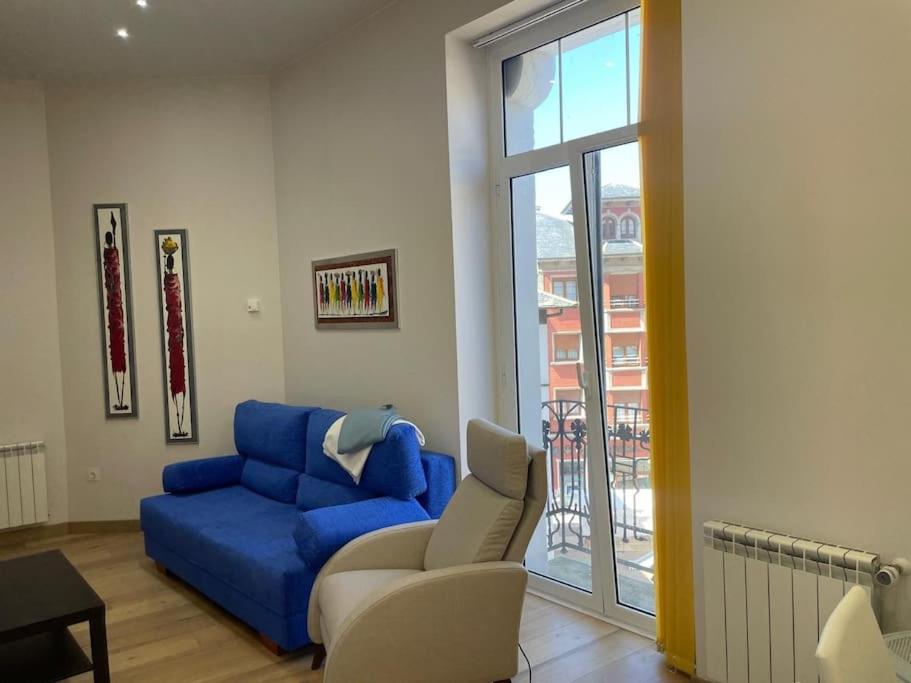a living room with a blue couch and a chair at Marinera in Luarca