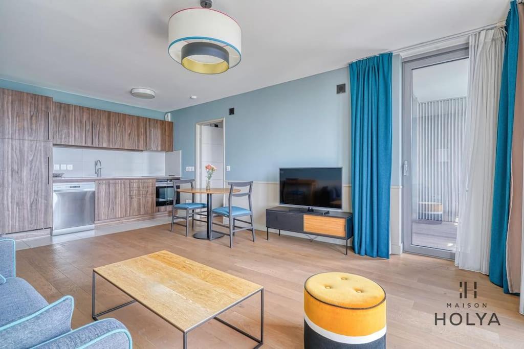 un salon avec une table et une cuisine dans l'établissement Le Vivant - À Auteuil - 359B, à Paris