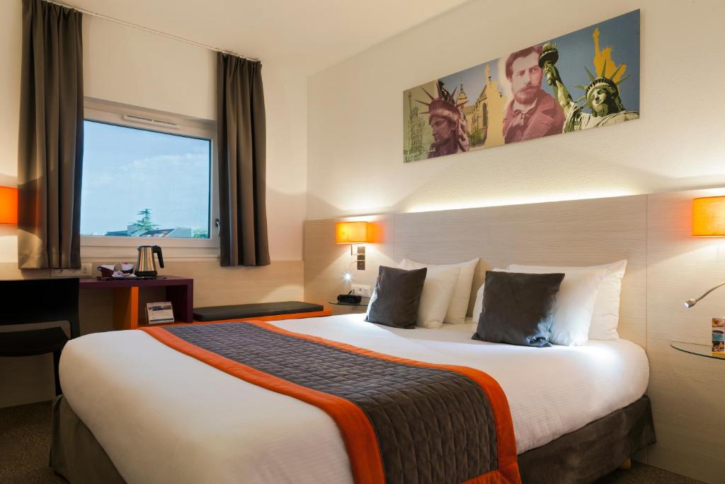 ein Hotelzimmer mit einem großen Bett und einem Fenster in der Unterkunft Best Western Colmar Expo in Colmar