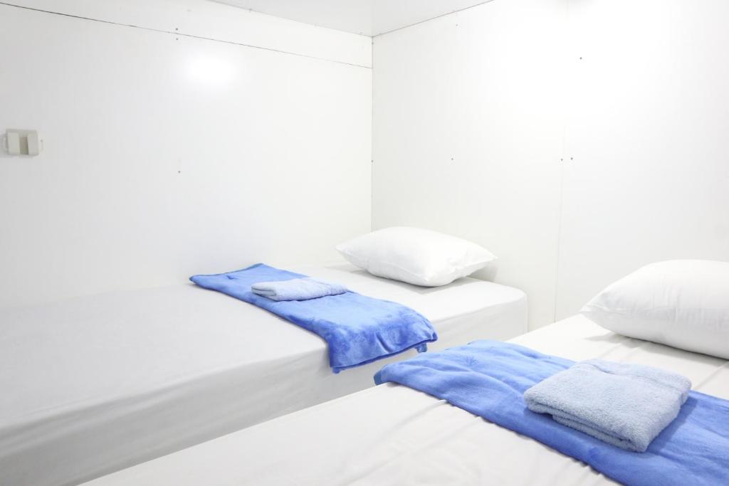Postel nebo postele na pokoji v ubytování TAMU CAPSULE HOTEL