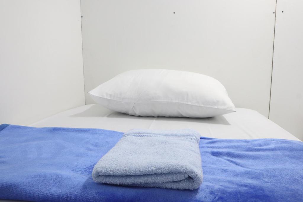 Postel nebo postele na pokoji v ubytování TAMU CAPSULE HOTEL