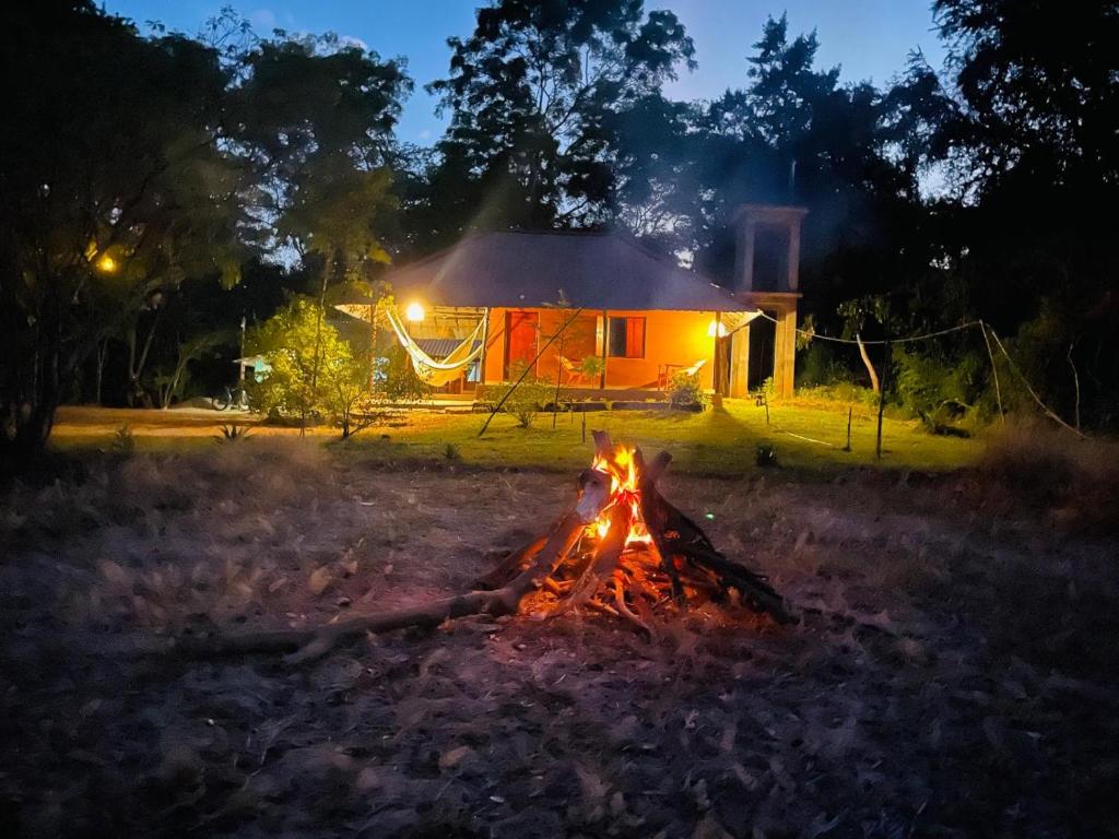 a campfire in front of a house at night at Sahana Retreat in Buttala