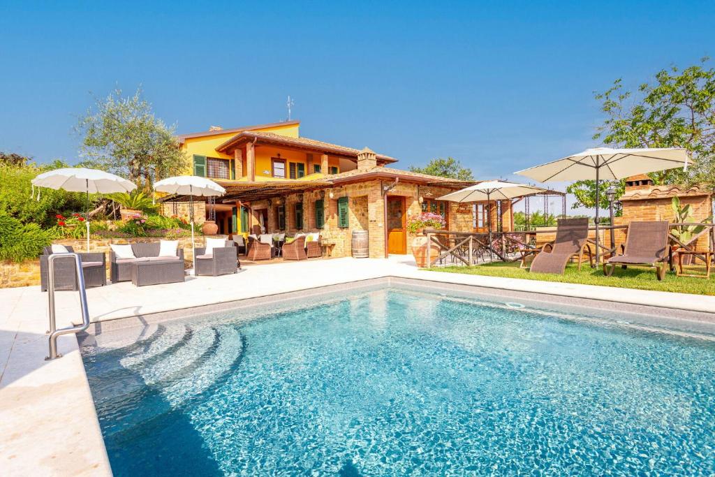 a swimming pool in front of a house at Villa Amadeo by PosarelliVillas in Montaione