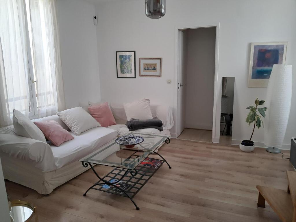 un salon avec un canapé blanc et une table dans l'établissement In the heart of Le Marais Paris, à Paris