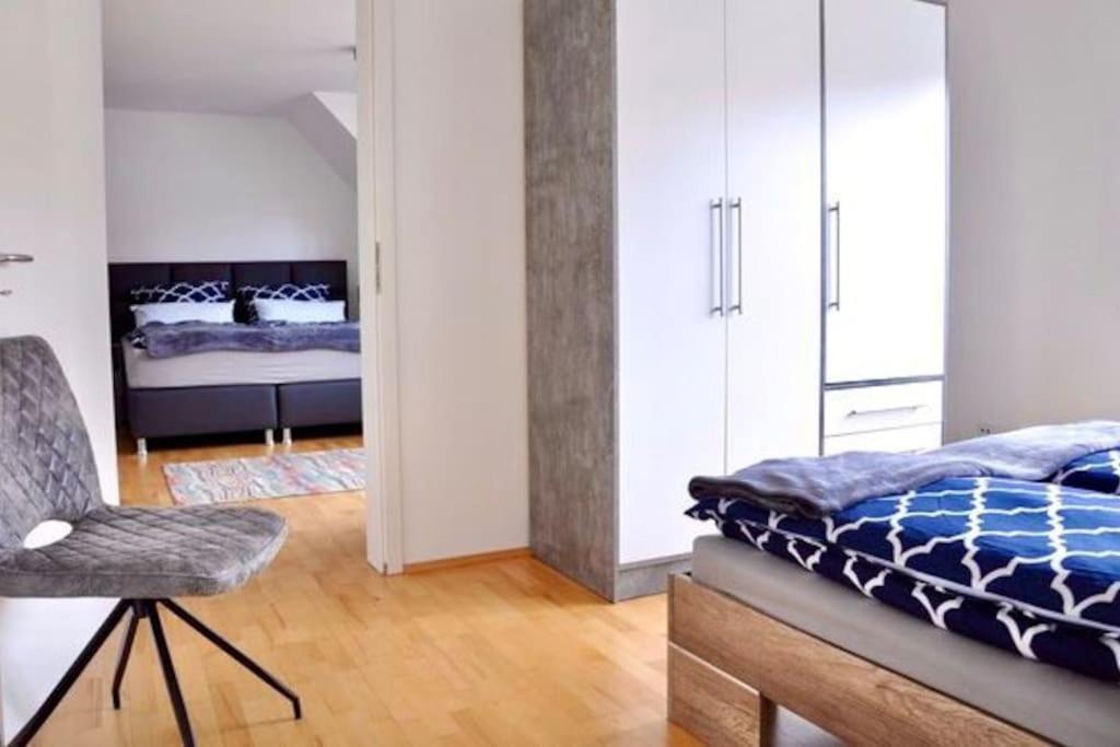 a bedroom with a bed and a chair in it at SH-Apartment Penthouse 44 - zentral & einzigartig in Erfurt