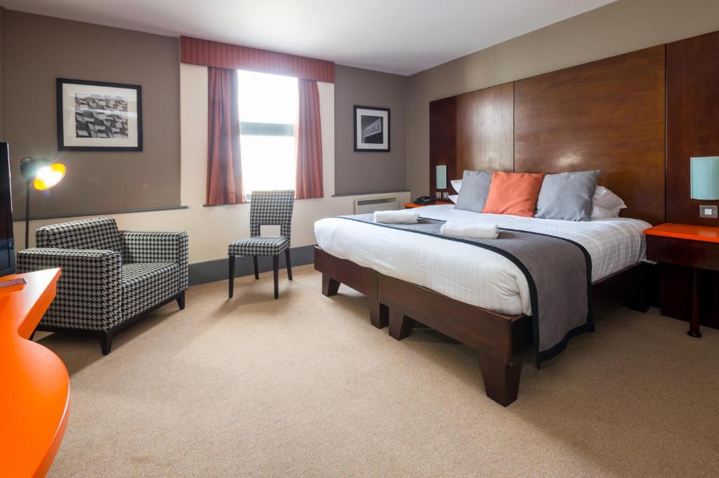 シェフィールドにあるBest Western Sheffield City Hotelの大きなベッドと椅子のあるホテルの部屋