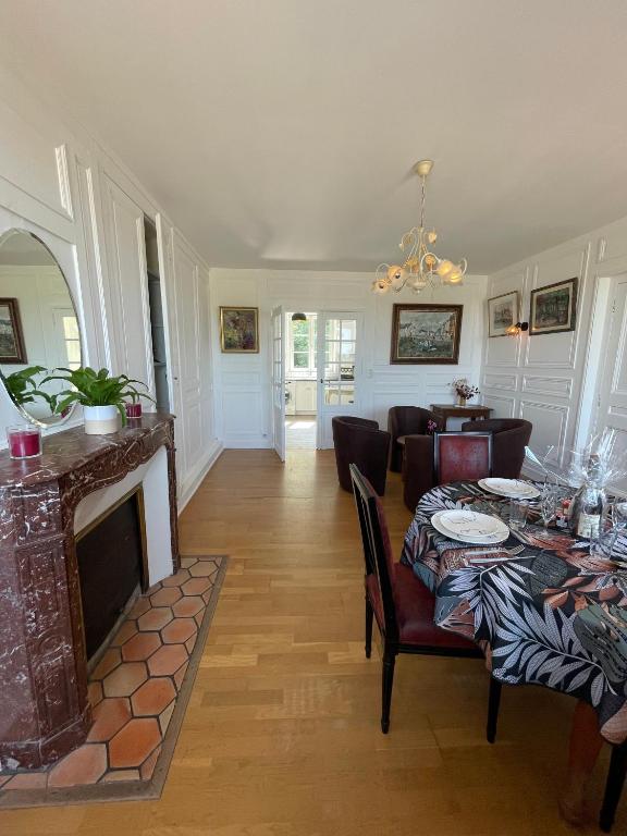 un salon avec une table et une cheminée dans l'établissement Le Bassin, à Honfleur