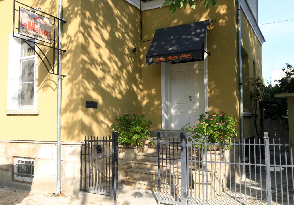 una casa amarilla con una valla delante de ella en La Maison Ruse, en Ruse