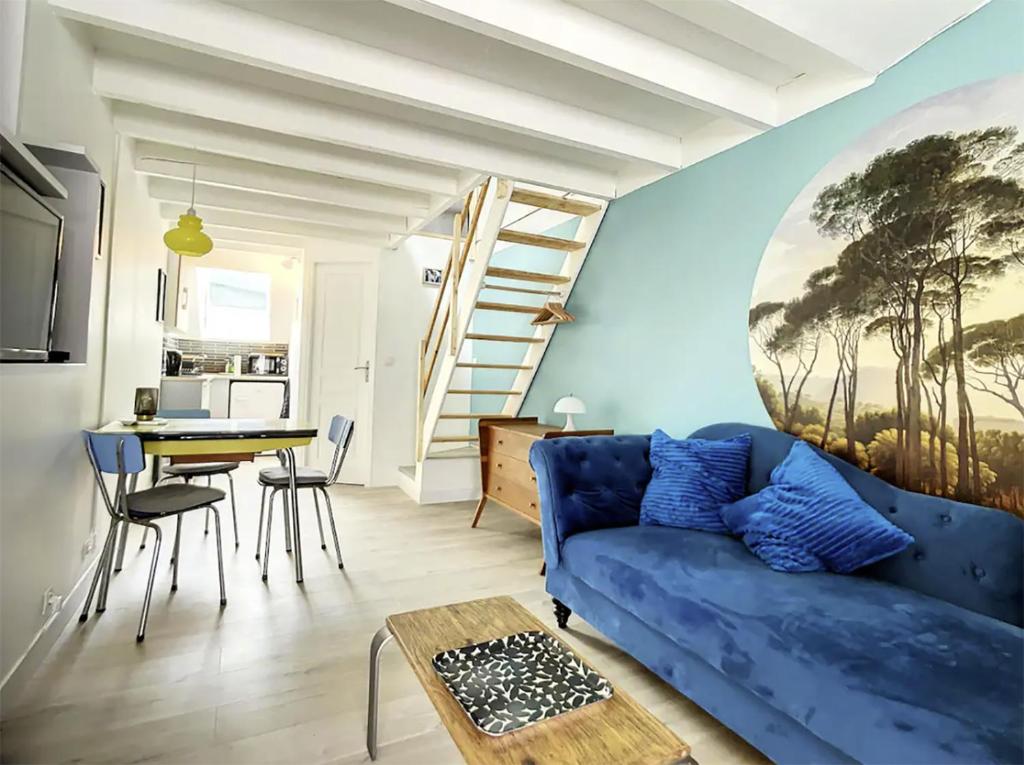 un salon avec un canapé bleu et une table dans l'établissement Chez Mily Joli petit duplex plein centre Villers Cotteret draps et serviettes fournis, à Villers-Cotterêts