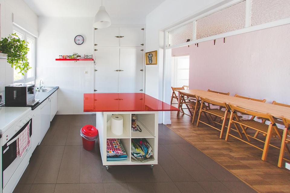 a kitchen with a red counter and a dining room at El Pez Escorpion in Salinas