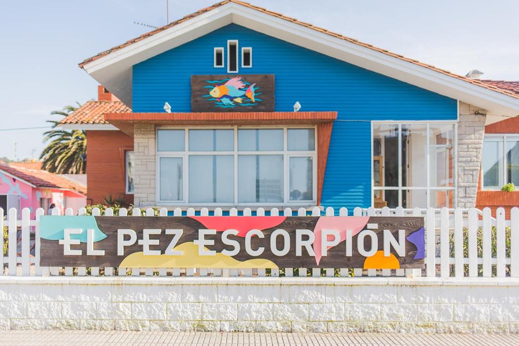 une maison bleue avec une clôture blanche devant elle dans l'établissement El Pez Escorpion, à Salinas