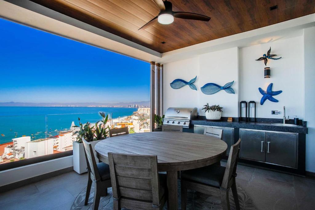 Una cocina con mesa y vista al mar. en Ocean View 2BD Retreat with Pool, en Puerto Vallarta