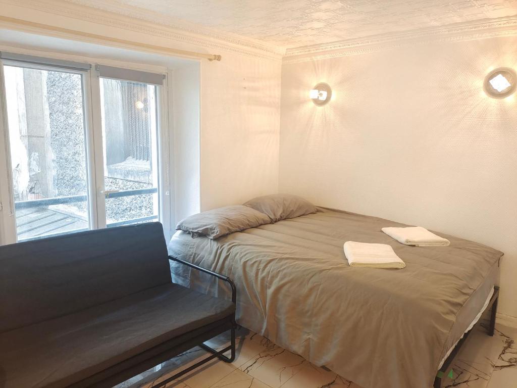 une petite pièce avec un lit et une fenêtre dans l'établissement Studio à 2 minutes de lafayette, à Paris