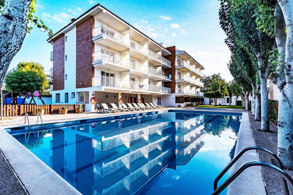 a swimming pool in front of a building at Apartamentos Sunway Atlanta in Sitges