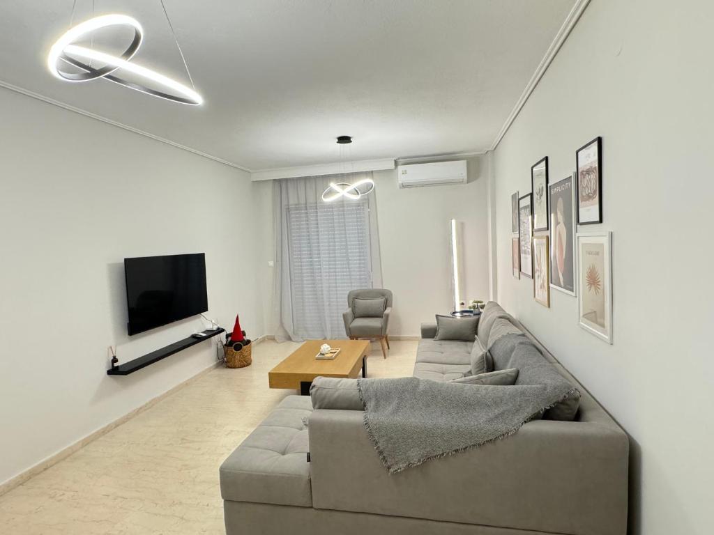 a living room with a couch and a tv at Be My Guest in Tríkala