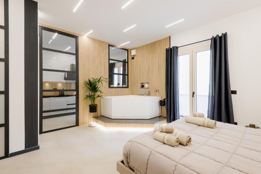 a bedroom with a large bed and a bath tub at Sunway Luxury Apartment in Alghero