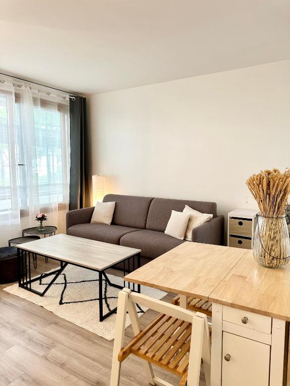un salon avec un canapé et une table dans l'établissement Appartment 5 min from Paris - parking included, à Levallois-Perret