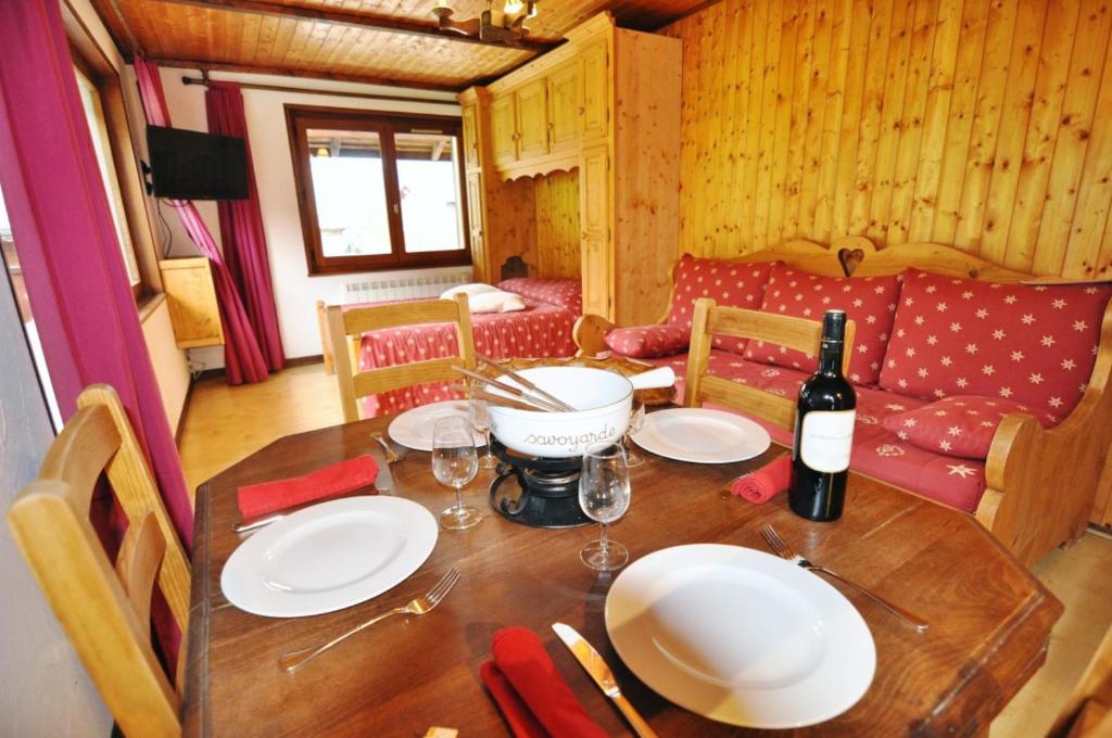 - une table avec des assiettes et une bouteille de vin dans l'établissement Les Cornettes de Bise, à La Chapelle-dʼAbondance