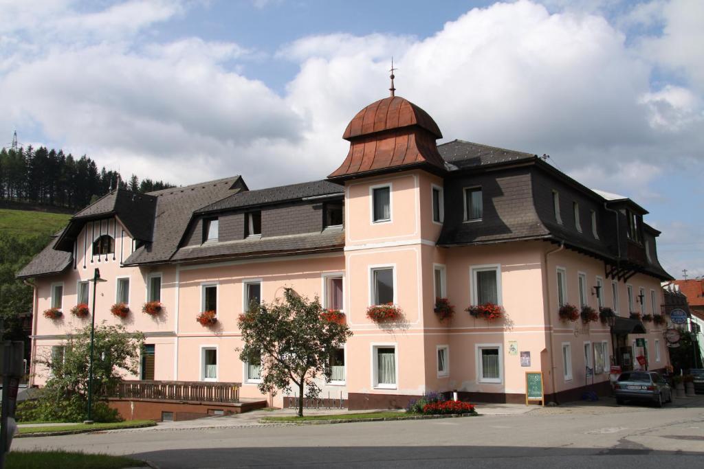 シュタインハウス・アム・ゼンメリングにあるFrühstückspension Gasthof Gesslbauerの黒屋根の白い大きな建物