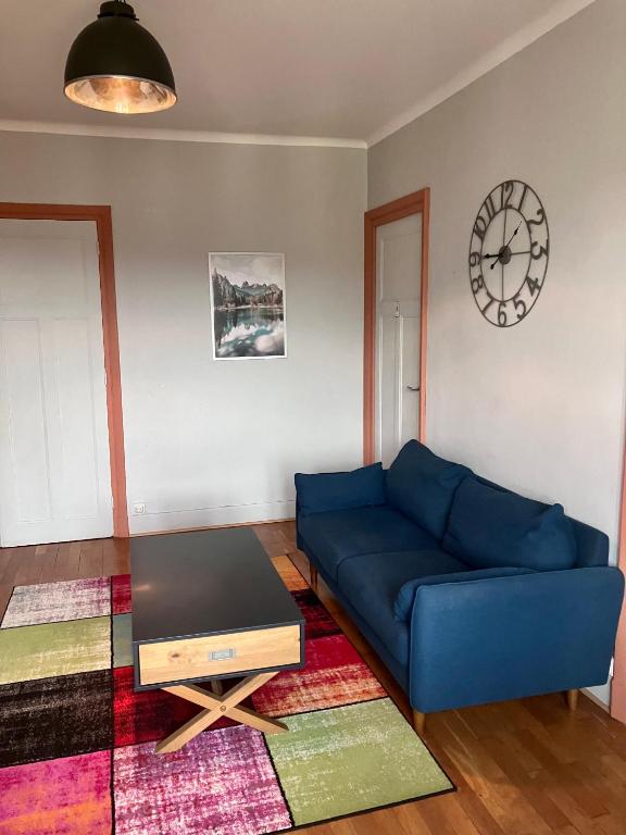 un salon avec un canapé bleu et un réveil dans l'établissement Appartement Cosy au cœur de Lyon, à Lyon