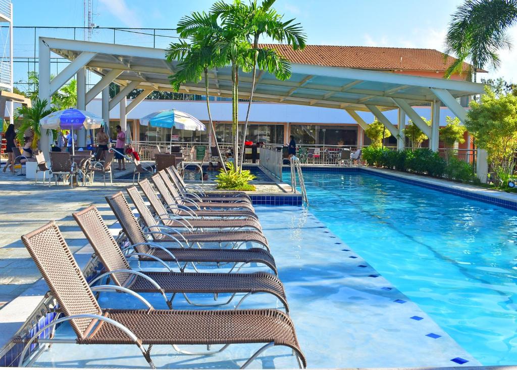 a row of chairs sitting next to a swimming pool at Nobrezafiori Diroma FIORI taxas de Roupas de Cama Banho e taxas do hotel valor a pagar na recepcao do hotel OBS MENOR DE 18 anos desacompanhado dos pais tem que ter autorizacao com RECONHECIMENTO de firma no cartório in Caldas Novas